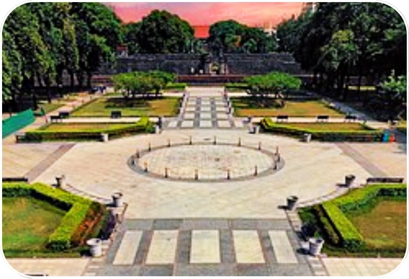 Fort Santiago entrance with landscaped gardens and stone pathways in Intramuros, Manila at sunset